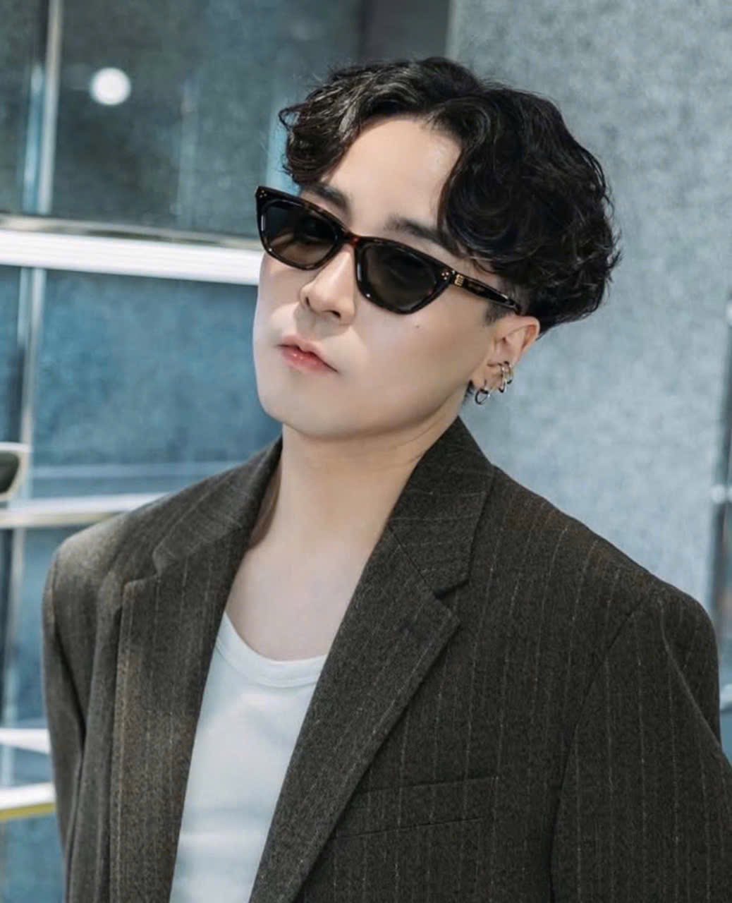 Person wearing Gentle Monster Gisele T1 Cat-Eye Sunglasses and a dark coat in an urban setting