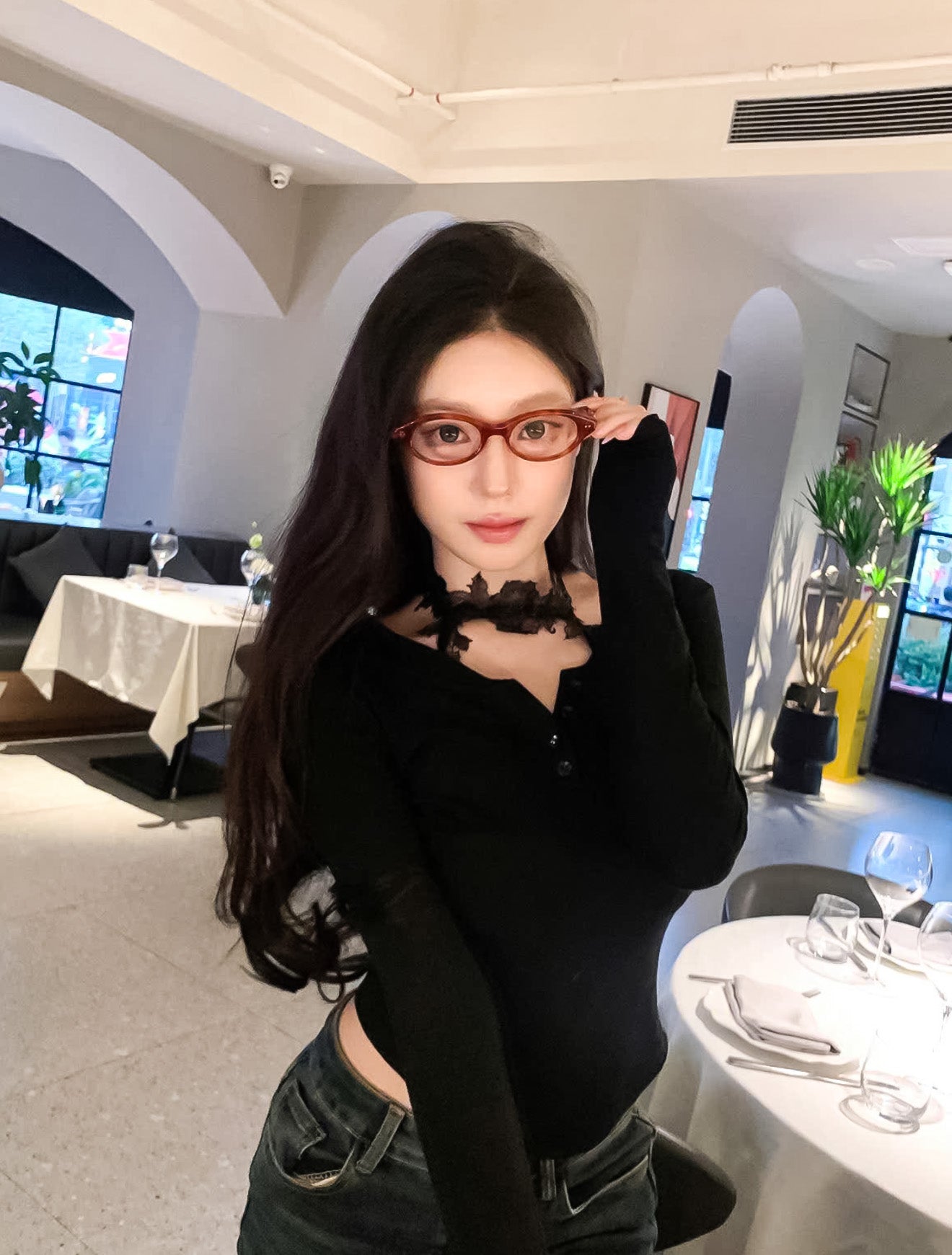 Woman wearing Gentle Monster - GM Corori T4 and a black top in a restaurant setting
