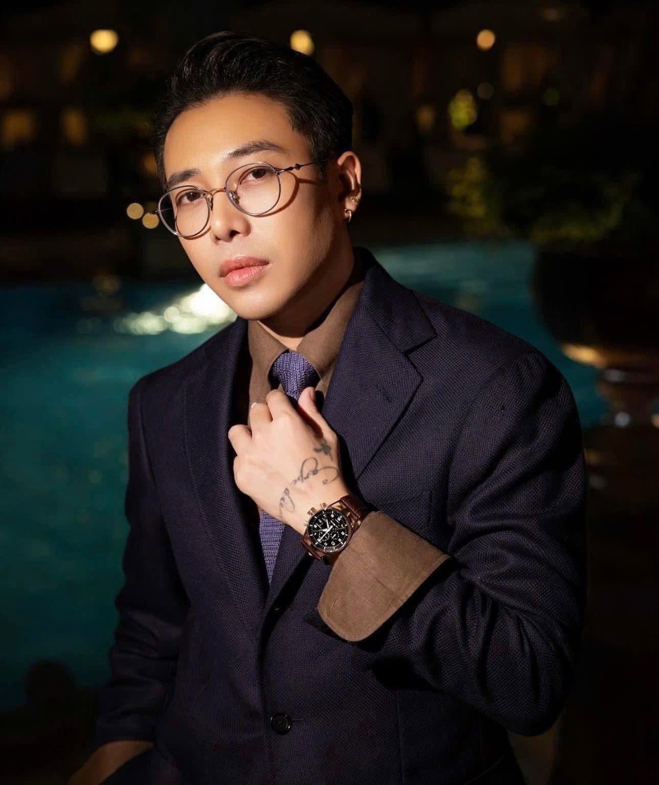 Man wearing a dark suit and Gentle Monster (GM) EP 02 with a blurred background