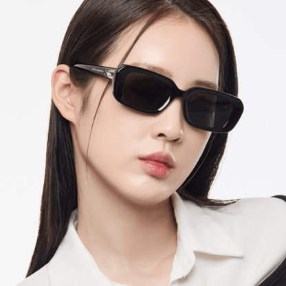 Woman wearing black sunglasses with a plain background