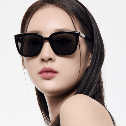 Woman wearing black sunglasses on a white background