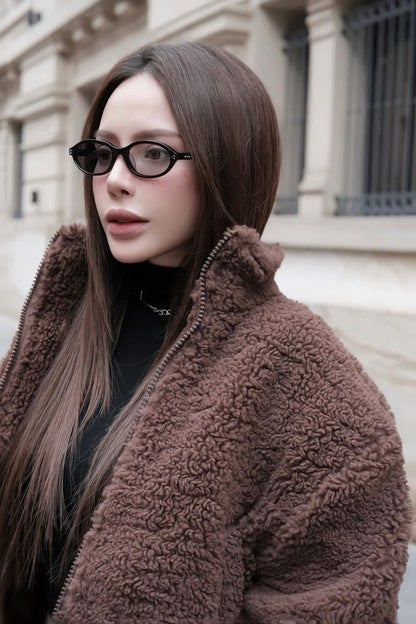 Woman wearing a brown fleece jacket and Gentle Monster La Cha 01(C) Round Optical Glasses outdoors.