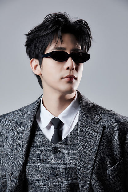 Wang An Yu wearing a gray suit and Gentle Monster Monica 01 Cat-Eye Sunglasses against a gray background
