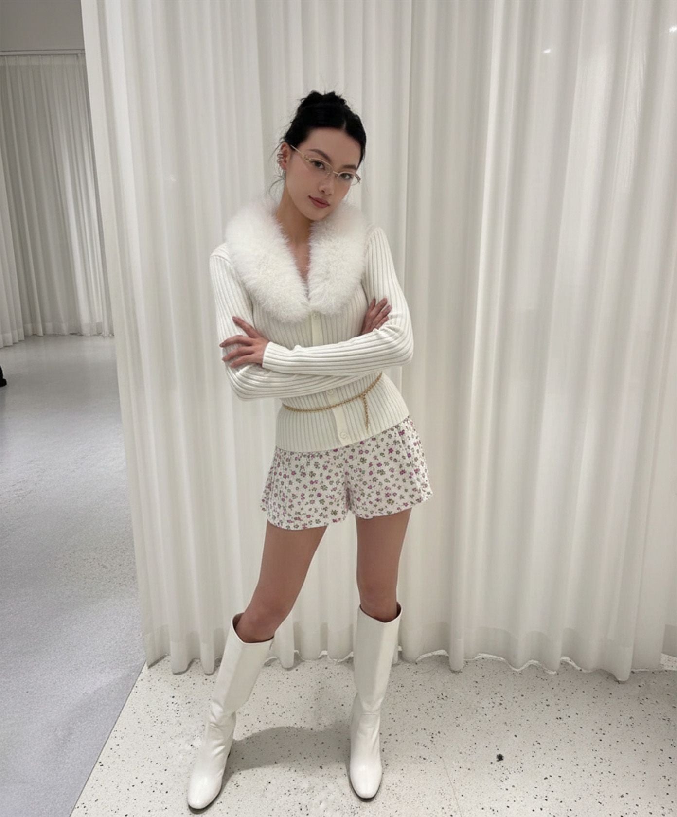 Woman wearing Gentle Monster Origami 031 in a white outfit with a fur collar in front of white curtains