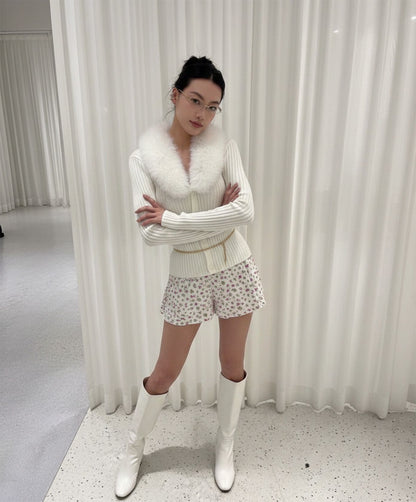 Woman wearing Gentle Monster Origami 031 in a white outfit with a fur collar in front of white curtains