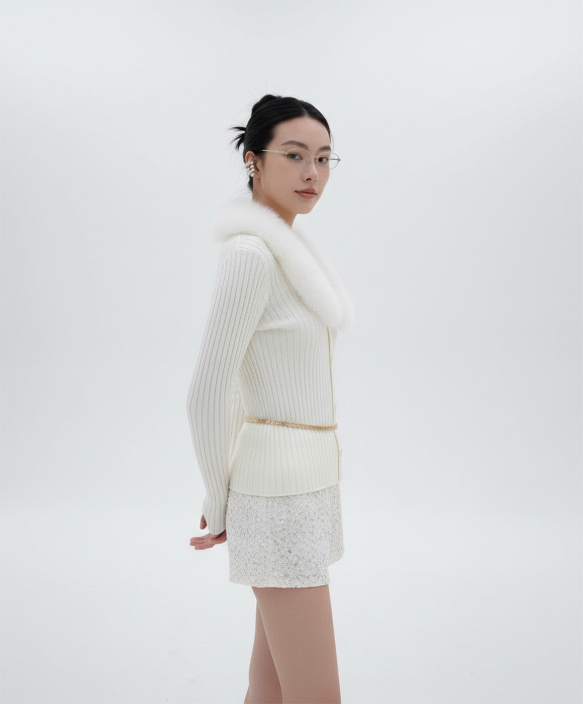 Woman wearing a Gentle Monster Origami 031  with white outfit with a fur collar against a white background