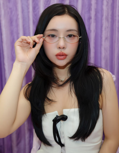 Woman adjusting Gentle Monster Pico 02 Oval Glasses against a purple curtain background