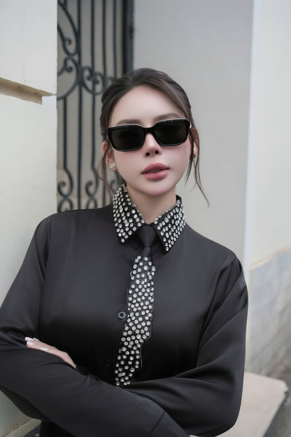 Person wearing a Gentle Monster Soho 01 in black outfit with a decorative collar in an indoor setting