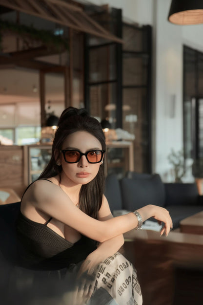 Woman wearing Gentle Monster Soho 01(BR) in a modern indoor setting