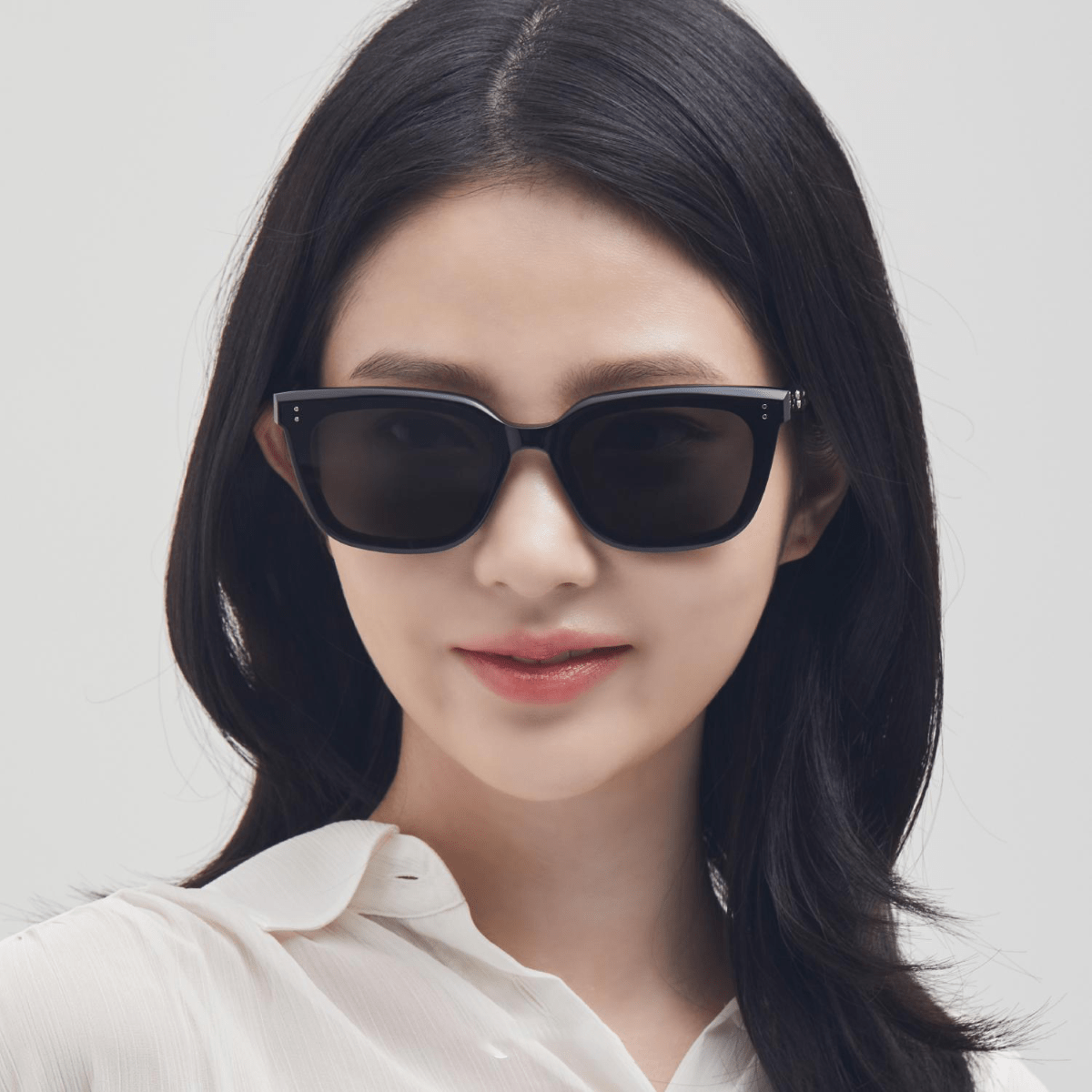 Woman wearing Gentle Monster (GM) Tote 01 with a plain background