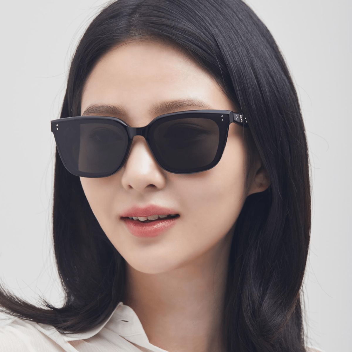 Woman wearing Gentle Monster (GM) Tote 01 with a plain background