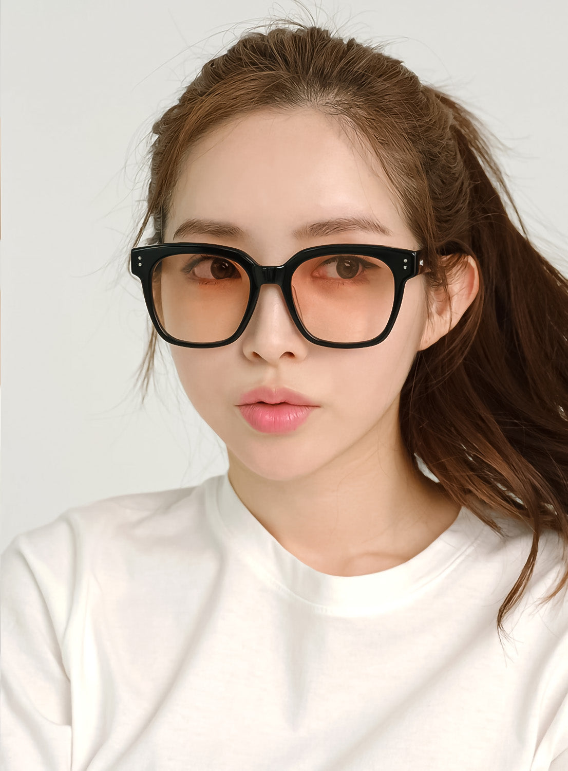 Women wearing Gentle Monster Una.C N 01(OR) Square Glasses with a plain white background