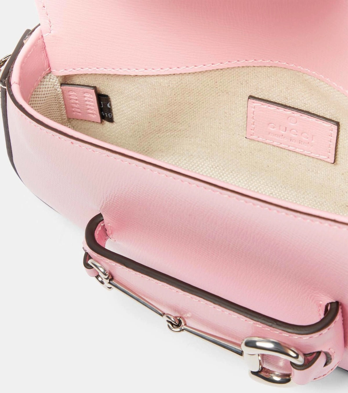 Open Close-up of a Gucci Asymmetrical Horsebit 1955 Mini Shoulder Bag Light Pink 774209-1DB0N-5823 with a visible brand label on a white background