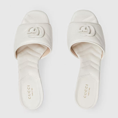 Pair of Gucci slides on a light gray background