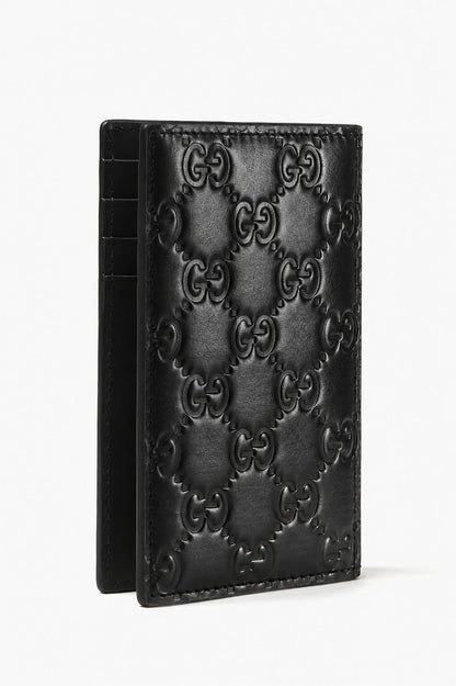 A Gucci GG Black Rubber-Effect Long Card Case 771317 AAC0L 1000 featuring the embossed Gucci GG monogram pattern, shown standing upright against a plain white background.