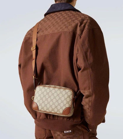 Person wearing a brown jacket with a matching Gucci GG Embossed Super Mini Cognac Beige Shoulder Bag 821216 FAED3 9786 on a light gray background