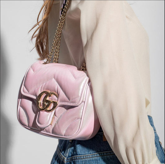 Gucci GG Marmont Iridescent Mini Crossbody Bag in Pink 739682 AAC2U 5826 with gold accents worn by a person against a neutral background