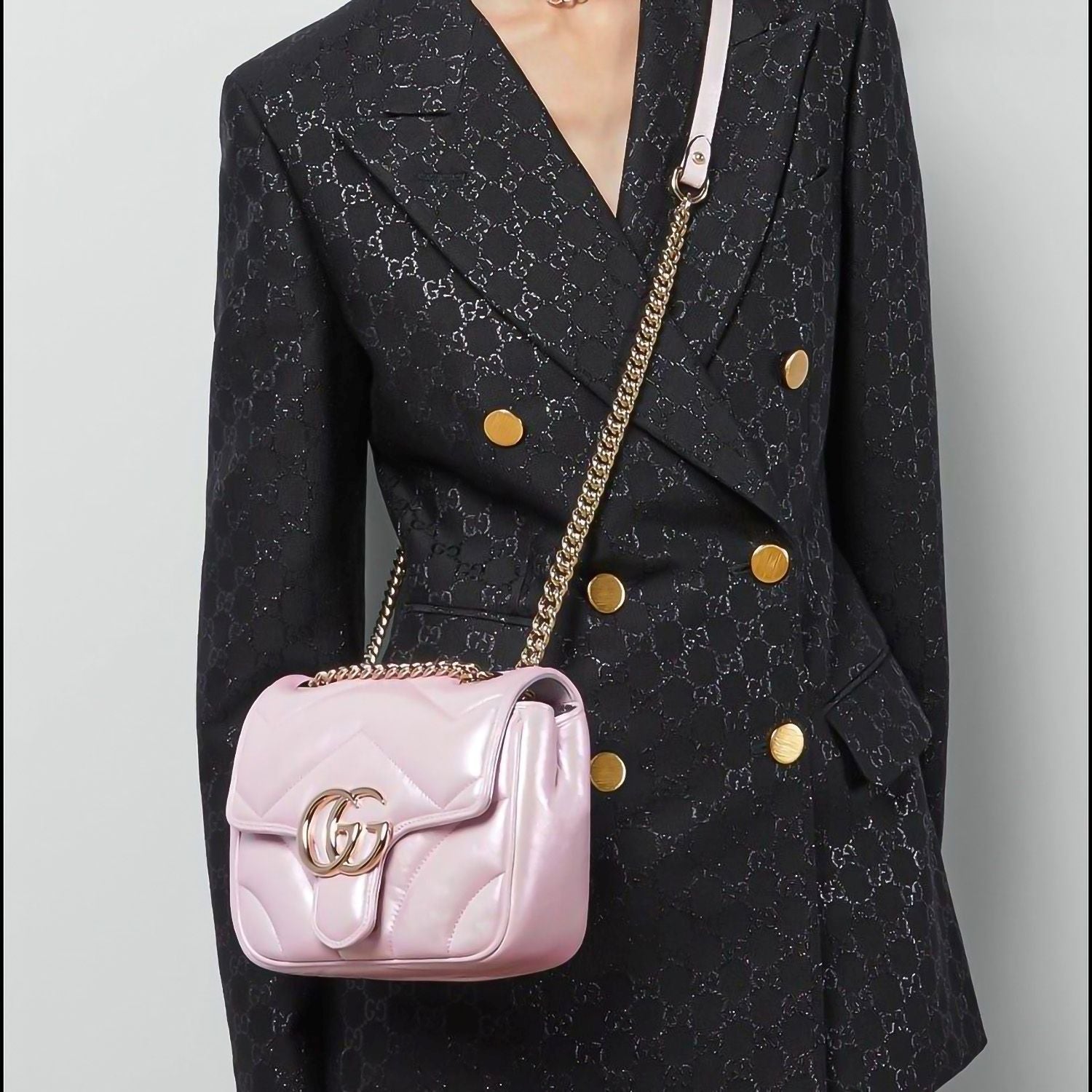 Person wearing a black patterned coat with a Gucci GG Marmont Iridescent Mini Crossbody Bag in Pink 739682 AAC2U 5826 featuring gold accents.