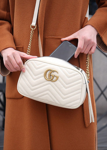 women holding Gucci GG White Marmont Small Crossbody Bag 447632 DTD1T 9022 putting the phone inside it