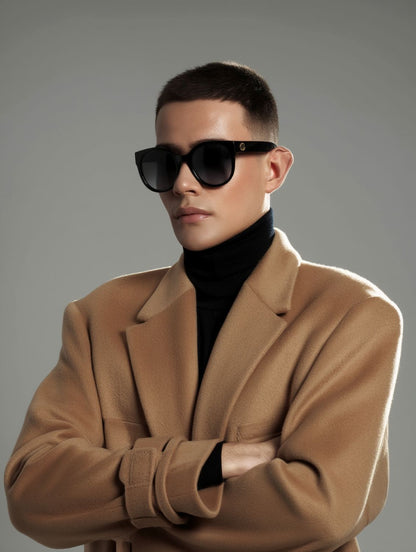 Man wearing a brown coat and Gucci GG0035SN-001 Round Sunglasses against a gray background