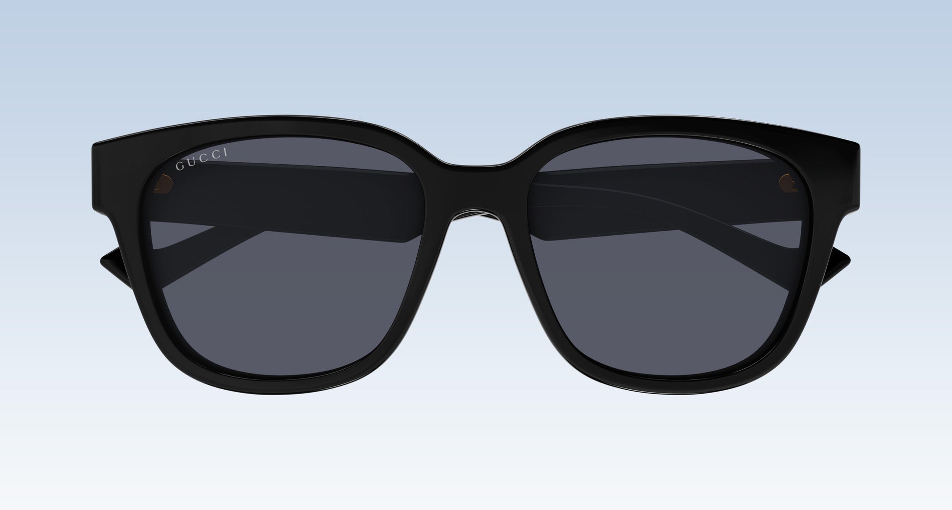 Gucci GG1430SK 001 Black Squared Sunglasses with a thick black frame and dark gray lenses, shown from the front against a light blue gradient background.