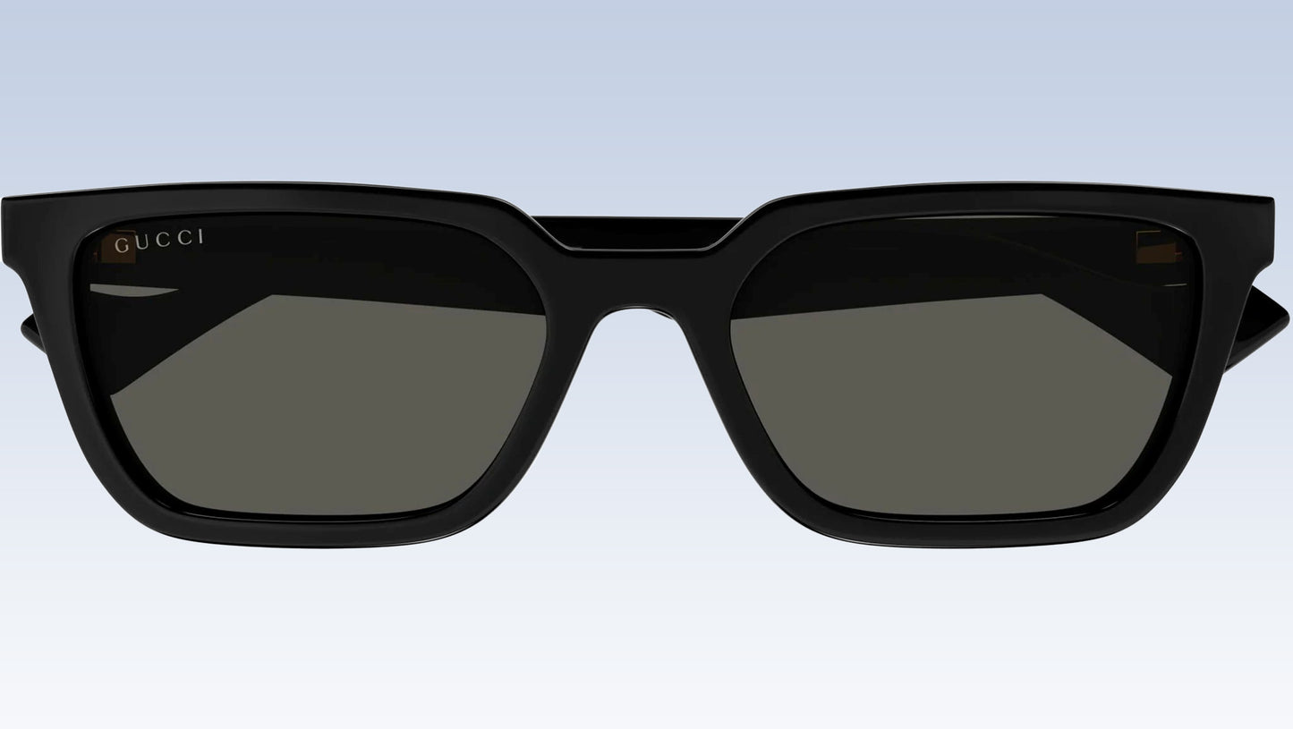 Gucci GG1539S 001 Black Rectangular Sunglasses with a glossy black frame and dark gray lenses, shown against a light blue gradient background.