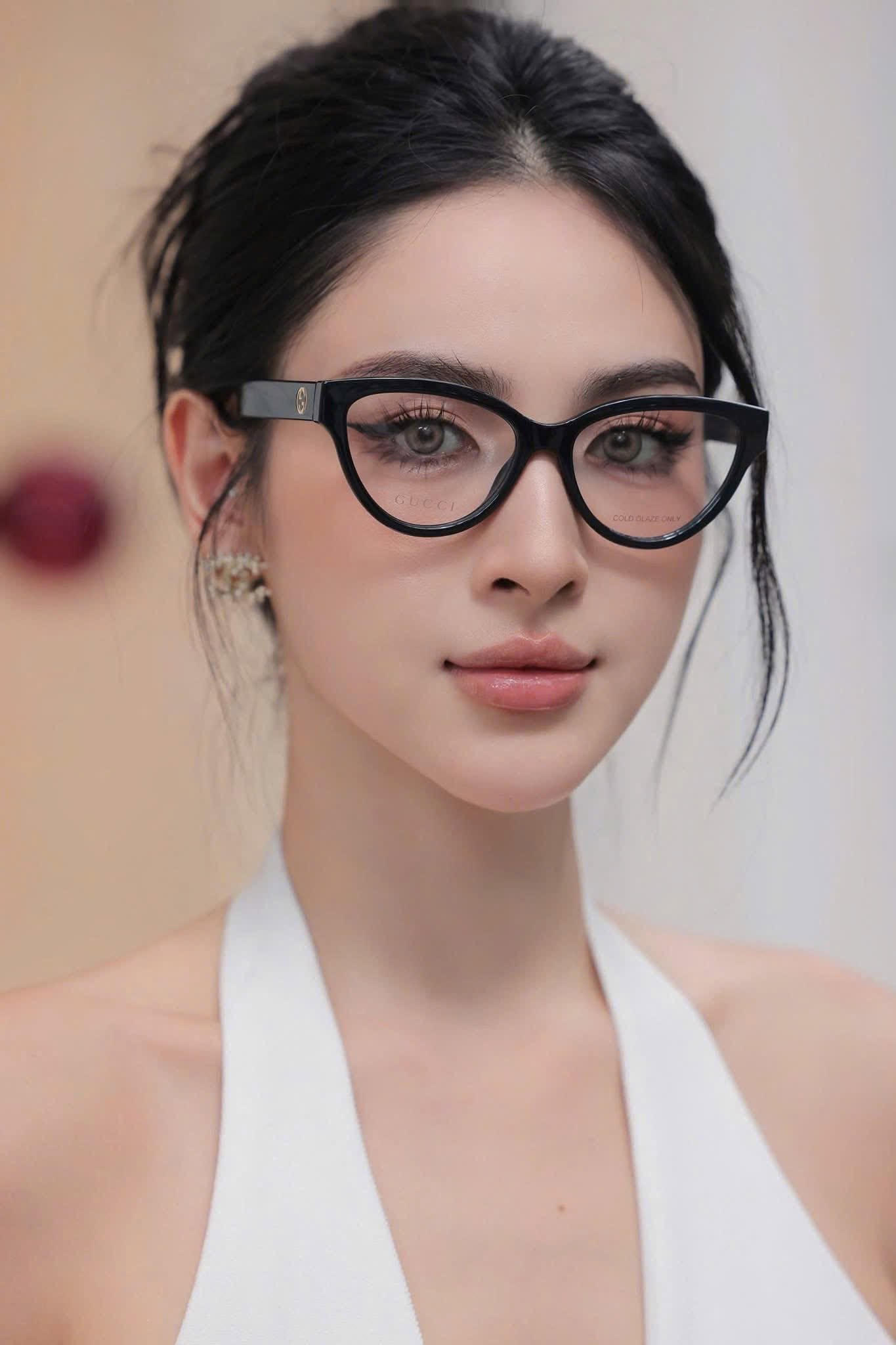 A close-up portrait of a woman wearing Gucci GG1581O Black Cat-Eye Eyeglasses with a silver metal hinge, paired with a white halter top.