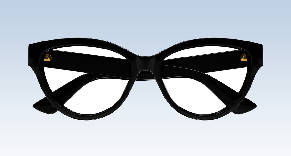 Gucci GG1581O Black Cat-Eye Eyeglasses with gold metal rivets on the temples, shown against a light blue gradient background.