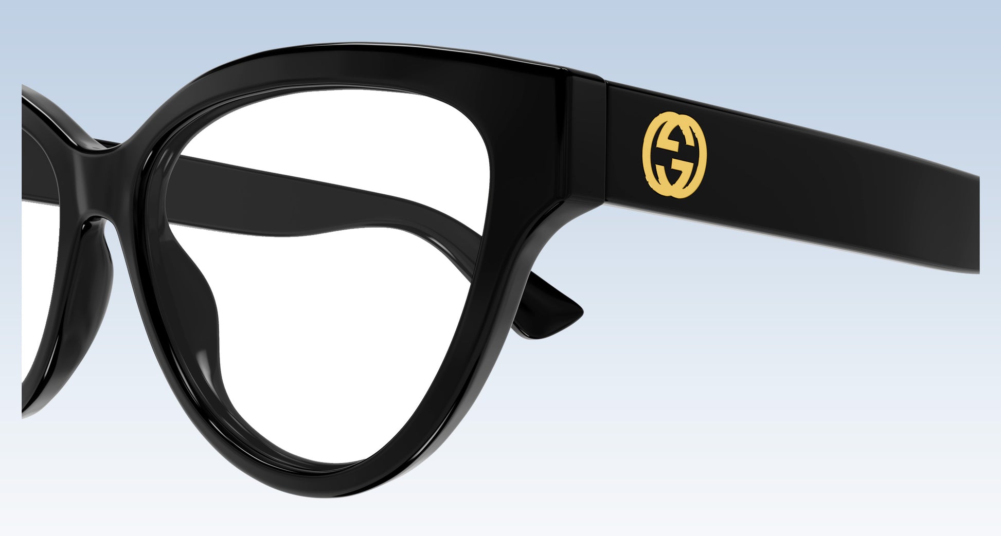 Gucci GG1581O Black Cat-Eye Eyeglasses in glossy black acetate with a signature gold interlocking GG logo on the temple arm, shown against a light blue gradient background.