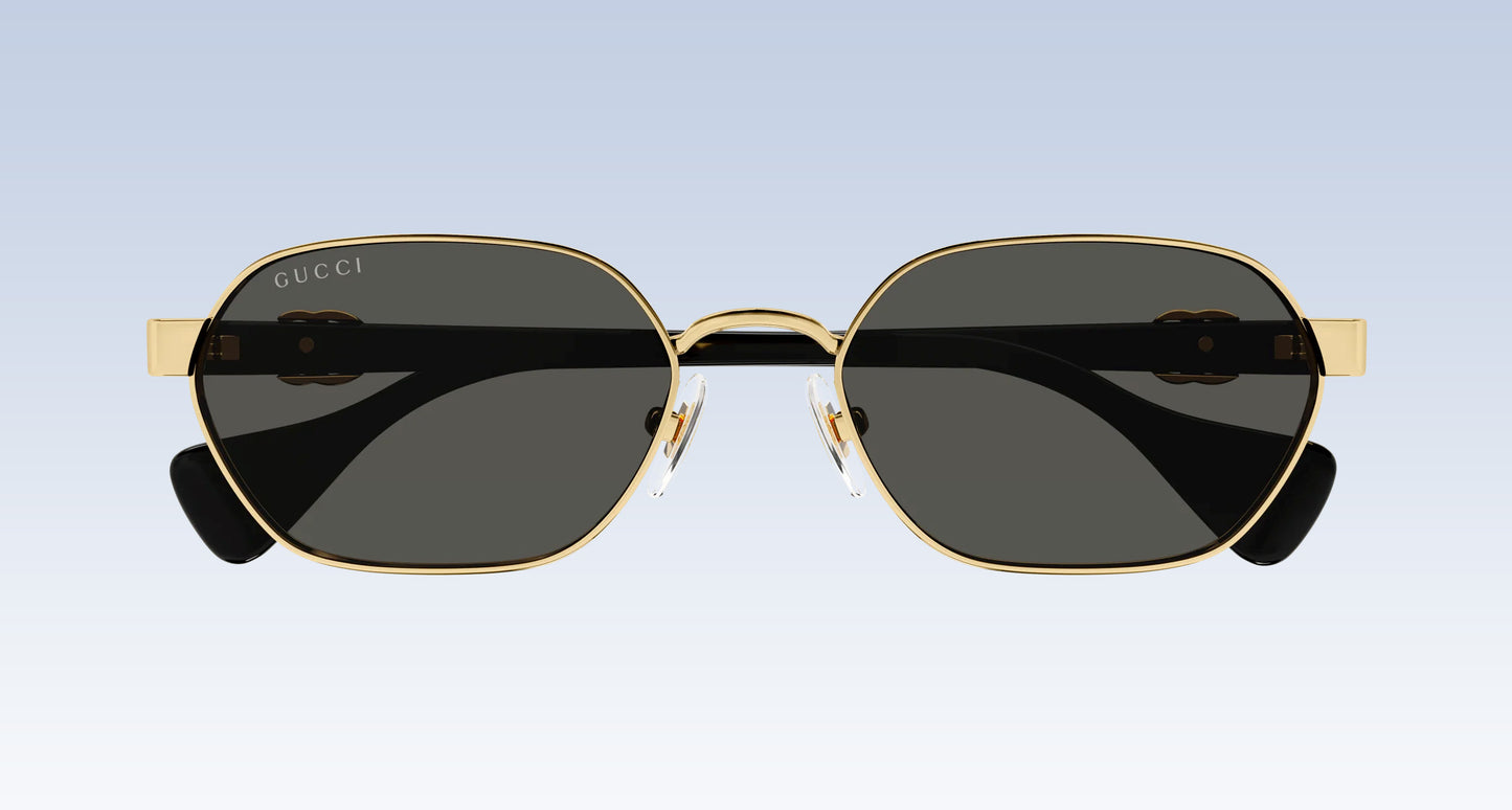 Gucci GG1593S 001 Gold Black Square Aviator Sunglasses with a gold-tone metal frame, dark gray lenses, and black temple tips, shown from the front against a light blue gradient background.