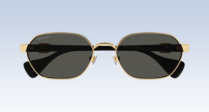 Gucci GG1593S 001 Gold Black Square Aviator Sunglasses with a gold-tone metal frame, dark gray lenses, and black temple tips, shown from the front against a light blue gradient background.
