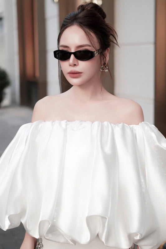 Woman wearing a white off-shoulder top with Gucci GG1660S 001 Oval Frame Sunglasses 785560 J1691 1012 and a blurred background