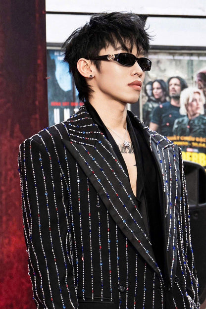 Kay Trần wearing a black and white striped blazer with Gucci GG1661S 001 Sunglasses in front of a movie poster.