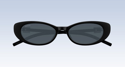 Gucci GG1680S 002 Black Oval Sunglasses with a glossy black frame and dark gray lenses, shown from the front on a light blue gradient background.