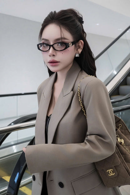 Woman wearing Gucci GG16930-001 Oval Eyeglasses in a beige blazer with a Chanel handbag in an indoor setting