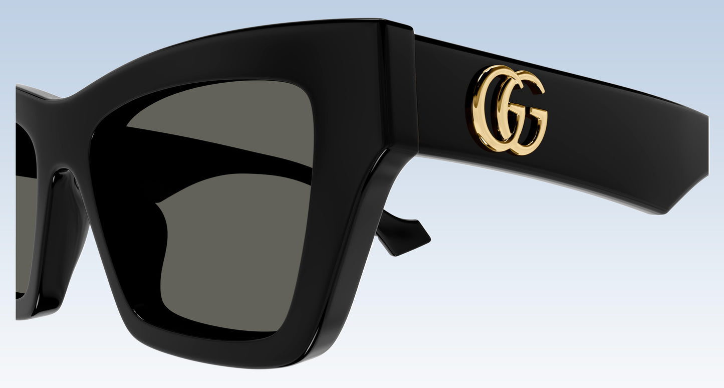 Gucci GG1753S 001 Black Square Sunglasses with a glossy black frame, dark gray lenses, and a gold interlocking GG logo on the temple arm, shown against a light blue gradient background.