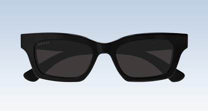 Gucci GG1790S 001 Black Rectangular Sunglasses with a glossy black frame and dark tinted lenses, shown from the front against a light blue gradient background.