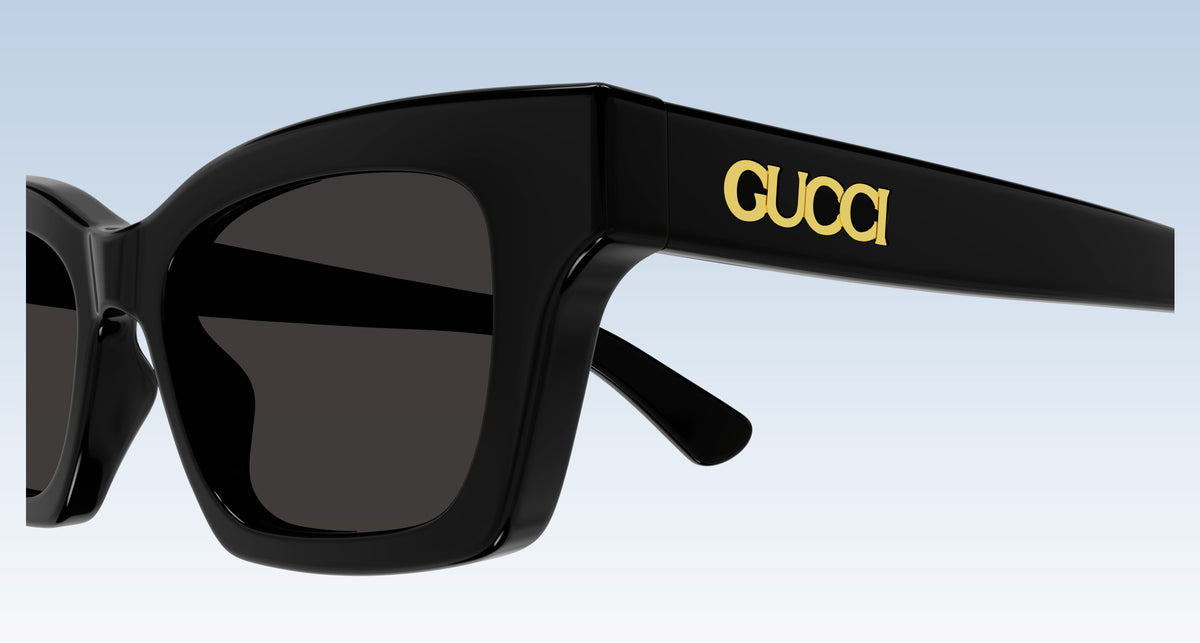 close-up Gucci GG1790S 001 Black Rectangular Sunglasses with the letter "Gucci" gold metal finished