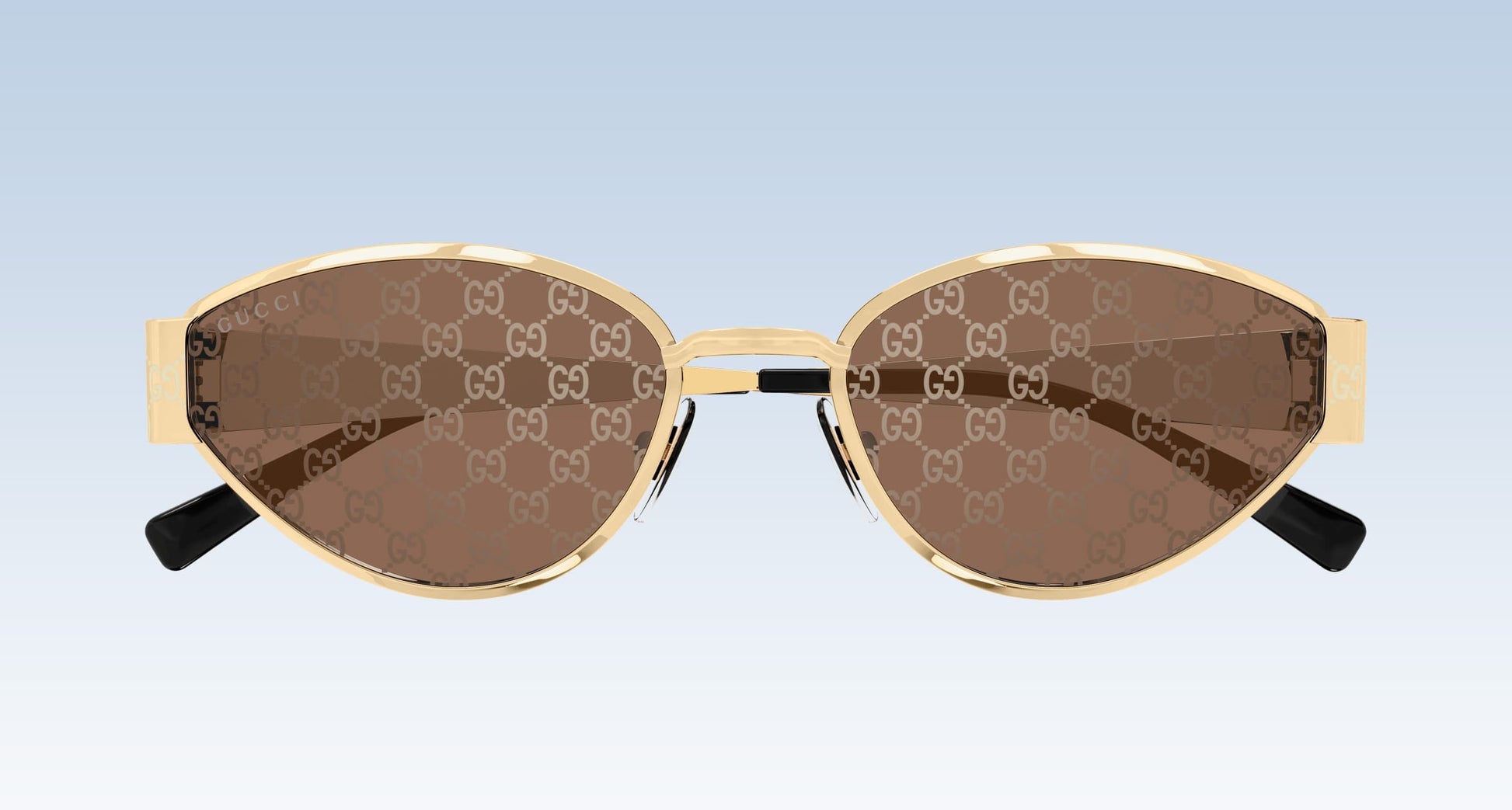 Gucci GG1853S 003 GG double-G patterned brown sunglasses with gold-tone metal frames and black temple tips, shown against a light blue gradient background.