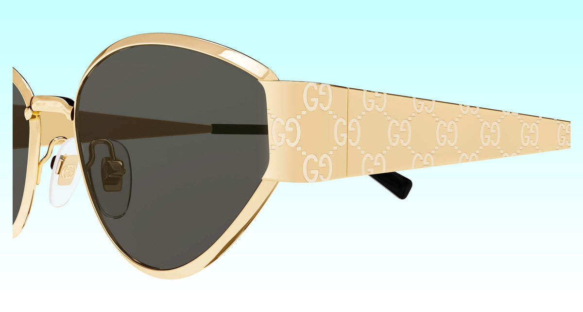 Close-up side view of Gucci GG1853S 001 Gold Butterfly Sunglasses with a gold-tone frame, dark lenses, and a beige temple featuring the repeating Gucci GG monogram.