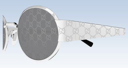 Gucci GG1854S 002 Silver Round Sunglasses with silver-tone metal frames, gray GG monogram lenses, and white temples featuring the signature GG pattern, shown on a light blue gradient background.