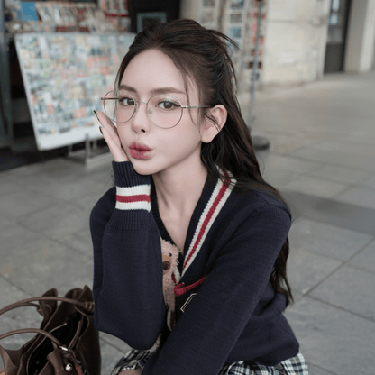 Woman wearing Gucci GG1939O 002 Silver Eyeglasses and a dark sweater with a plaid skirt in an outdoor setting