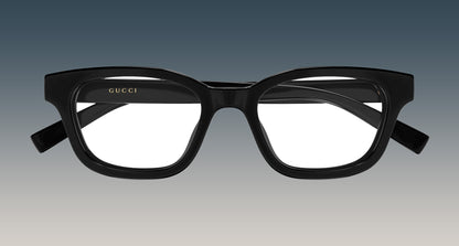 Gucci GG2103OL-001 Black Rectangular Eyeglasses with a thick, rounded rectangular frame and gold logo lettering on the inner left frame, shown against a gradient gray background.