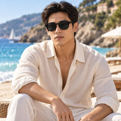 man wearing Gucci GG2109SK 001 Black Round Square Sunglasses in linen shirt sitting on the beach lounger