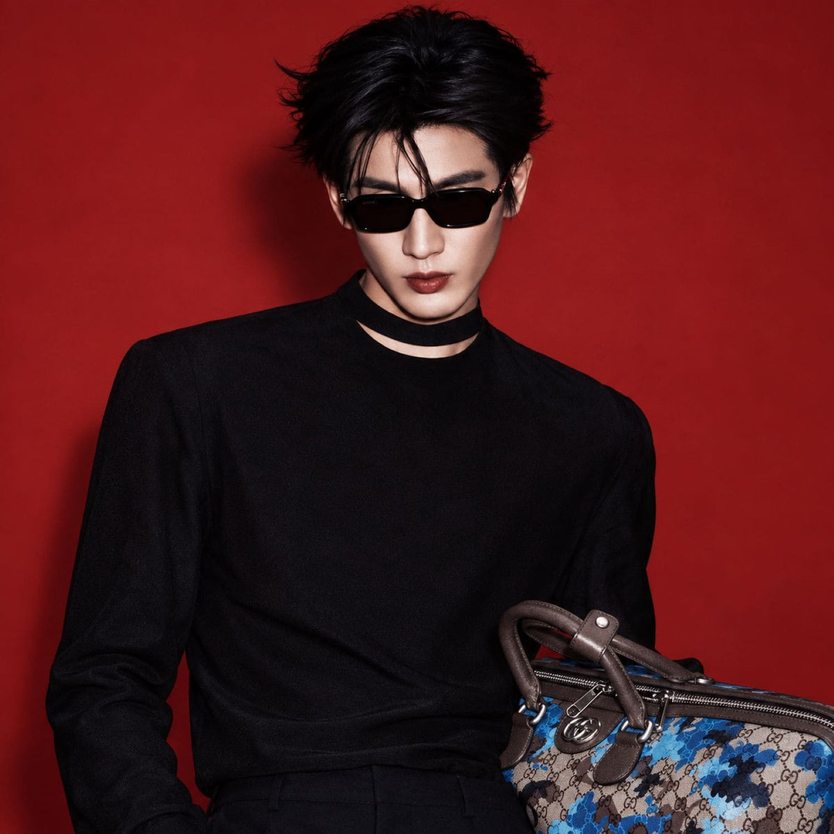 Man wearing Gucci GG2152S 001 Black Rectangular Sunglasses holding Gucci Boston monogram bag