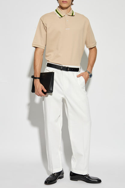 Person wearing a Gucci Green Black Stripe Collar Beige Polo 788024 XJGJY 2219, white pants, and black shoes on a white background