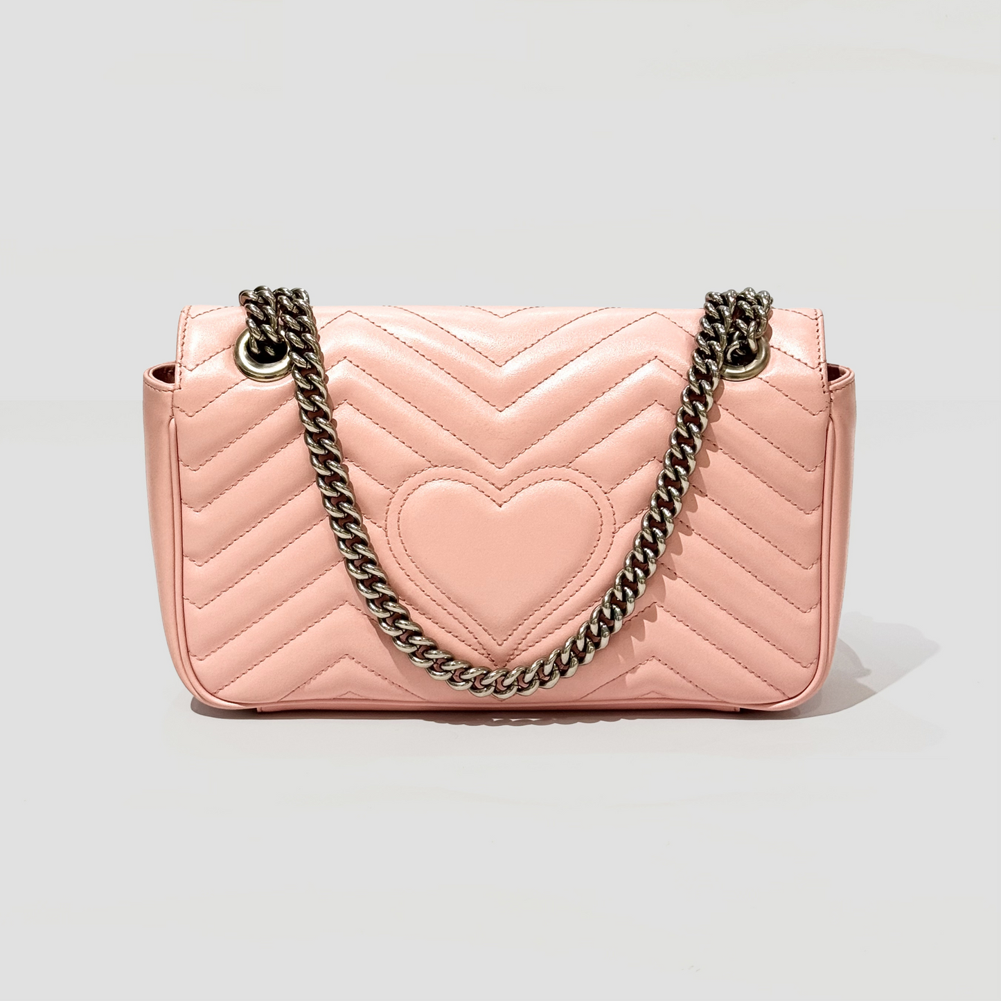 GUCCI MEDIUM MARMONT MATELASSÉ PINK SHOULDER BAG 443497 DTDIY 5815 with a heart design and chain strap on a light gray background