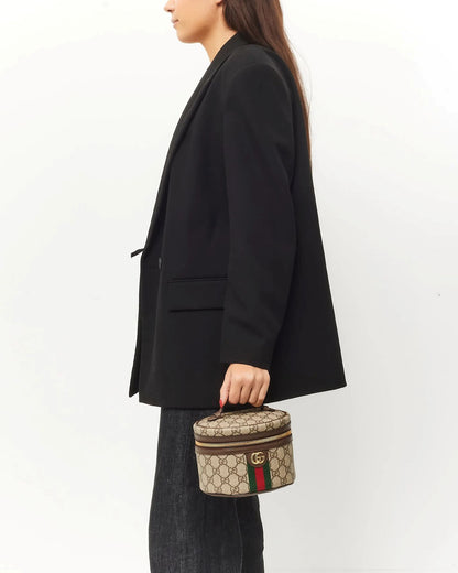Person holding a Gucci Mini Ophidia Cosmetic Case 627463-96IWG-8745 against a white background