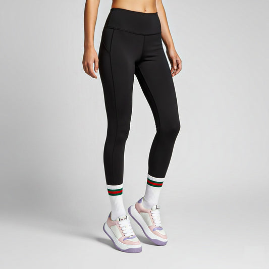Person wearing black leggings with Gucci Women Screener Pink Lilac Sneakers 813080 FADZQ 9161 on a gray background