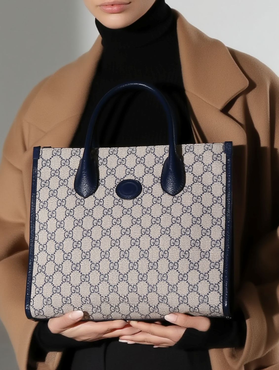 Person holding a Gucci Small Tote Bag With Interlocking G Navy 659983 K9GSN 4075 with blue accents